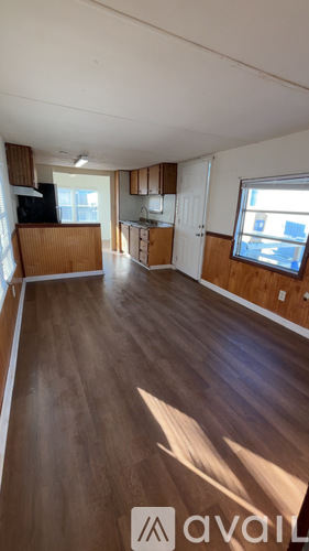 A living room with wooden floors and a large window.