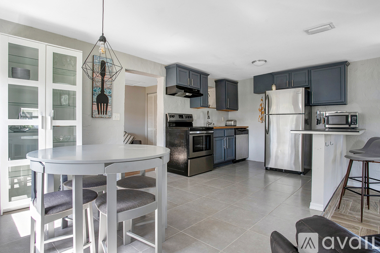 A kitchen with a table and chairs and a refrigerator.