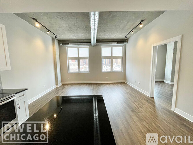 A spacious room with a black floor and wooden walls.