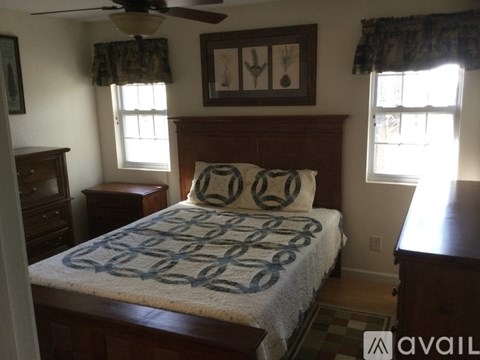 A bedroom with a bed, dresser, and window.