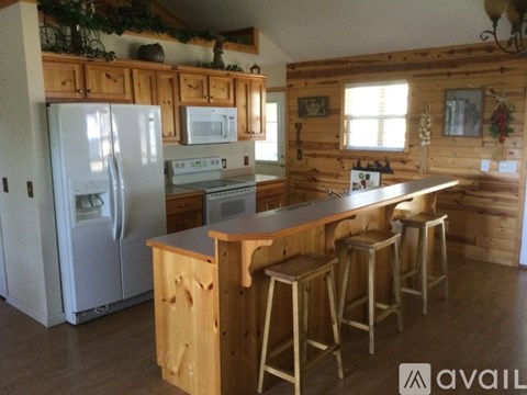 A kitchen with wooden cabinets and a white fridge.