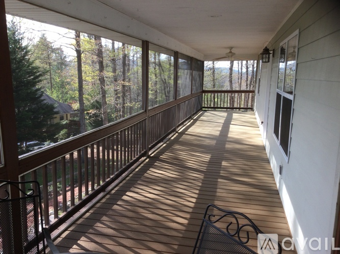 A sunny day on a balcony with a view of trees.