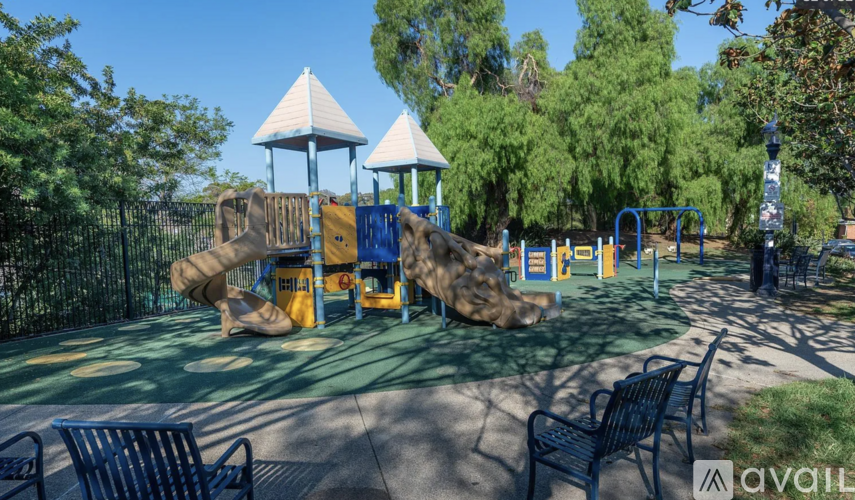 A playground with a slide, swings, and a climbing wall.