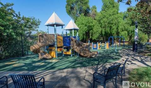 A playground with a slide, swings, and a climbing wall.