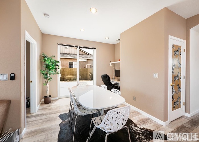 A dining room with a white table and chairs.