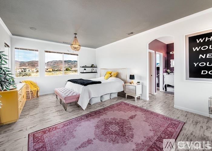 A bedroom with a large bed and a rug on the floor.