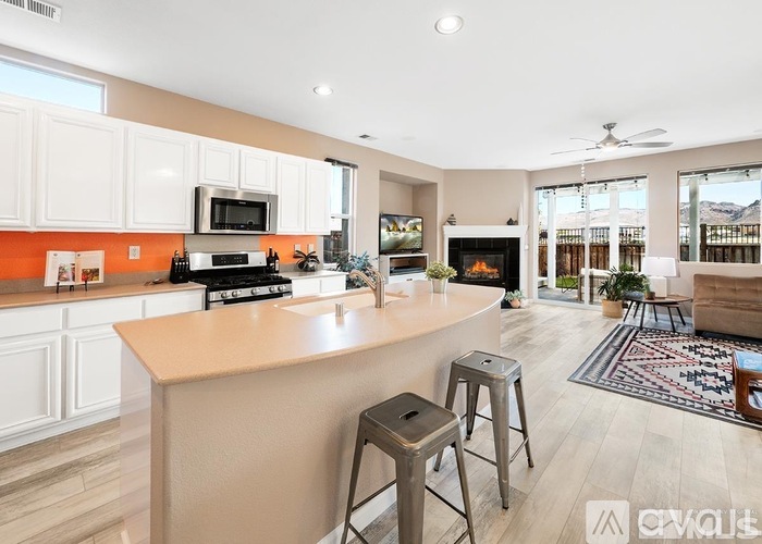 A kitchen with white cabinets and a wooden island.