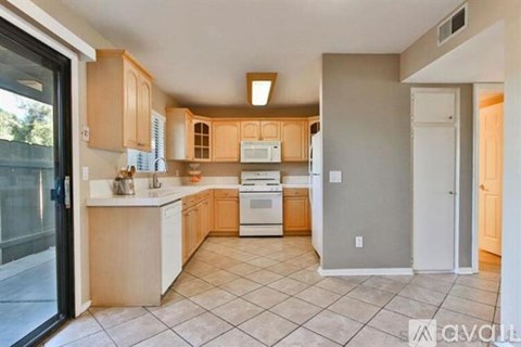 A kitchen with wooden cabinets and a white countertop.