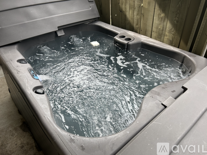 A hot tub with a grey exterior and water inside.