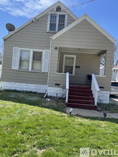A house with a grey siding and a red staircase.