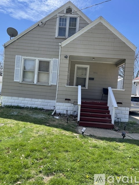 A house with a grey siding and a red staircase.