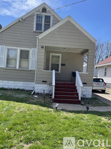 A house with a grey siding and a red staircase.
