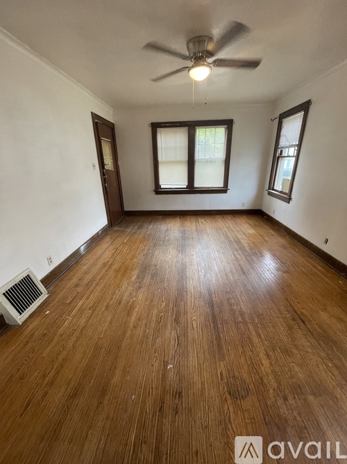A room with wooden flooring and a ceiling fan.