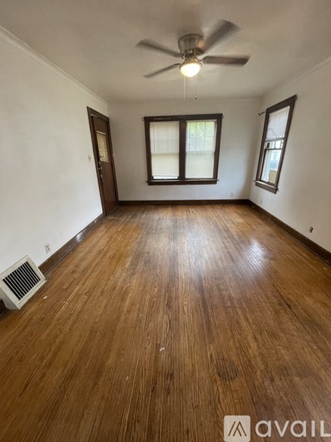 A room with wooden flooring and a ceiling fan.