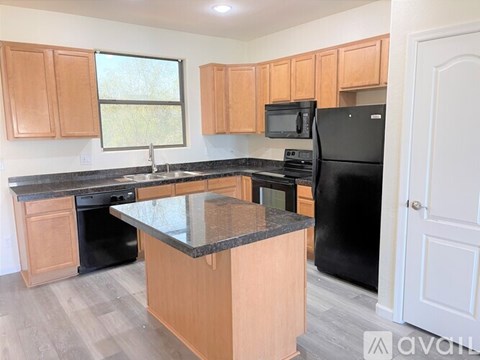 A kitchen with wooden cabinets and black appliances.