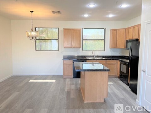 A kitchen with wooden cabinets and black appliances.