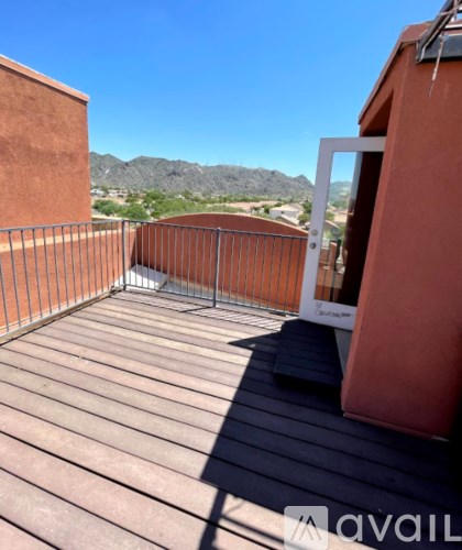 A balcony with a metal railing and a view of the mountains.