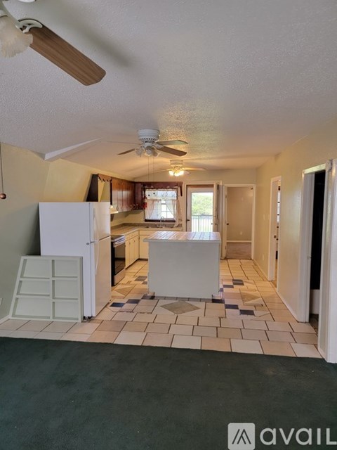 A kitchen with a white refrigerator and a ceiling fan.
