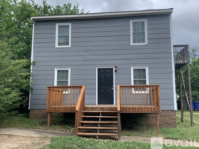 A grey house with a black door and windows.