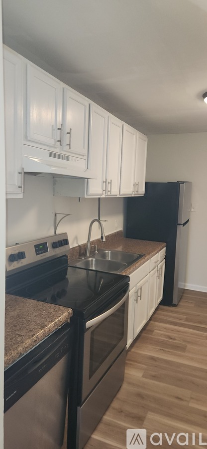 A kitchen with black appliances and white cabinets.