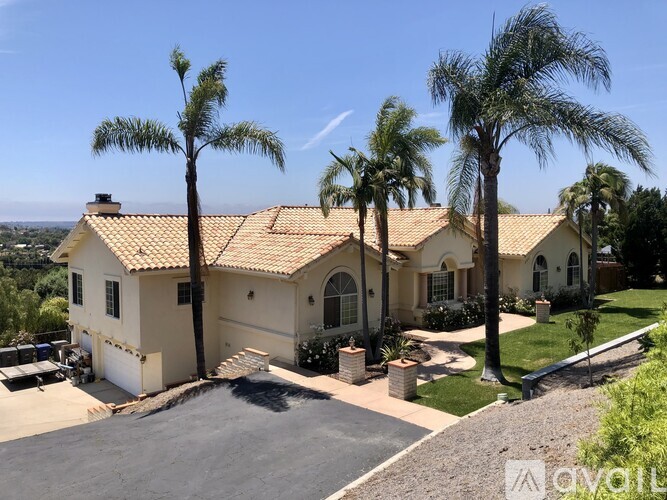 A house with a tiled roof and a driveway in front.