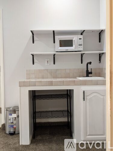 A kitchen with a white oven and microwave on the shelf.