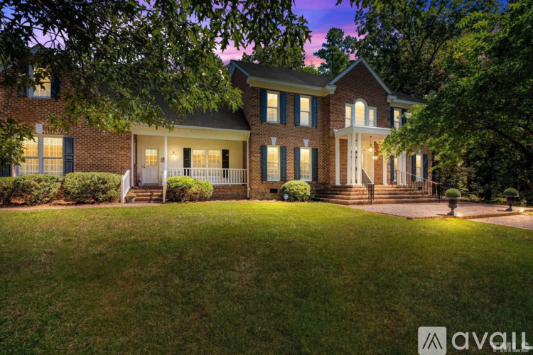 A house with a front yard and a tree in front of it.