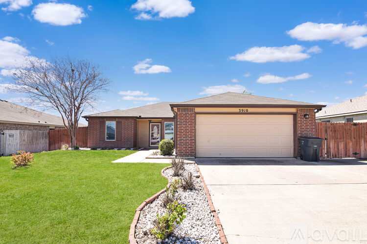 A house with a garage and a tree in front.