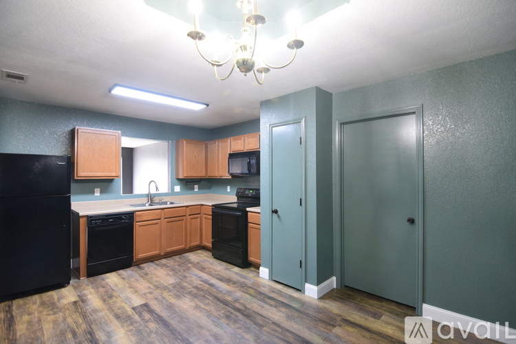 A kitchen with black appliances and wooden cabinets.