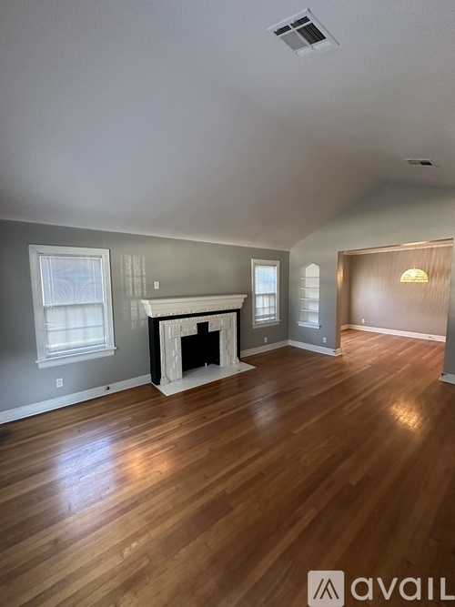 A living room with a fireplace and wood flooring.