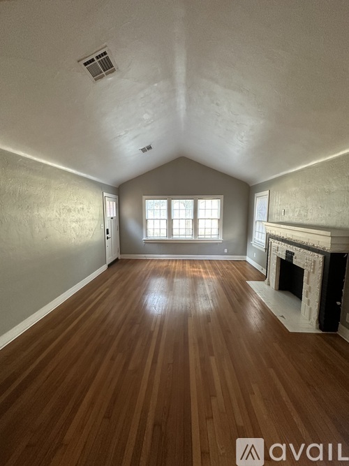 A room with wooden floors and a fireplace.
