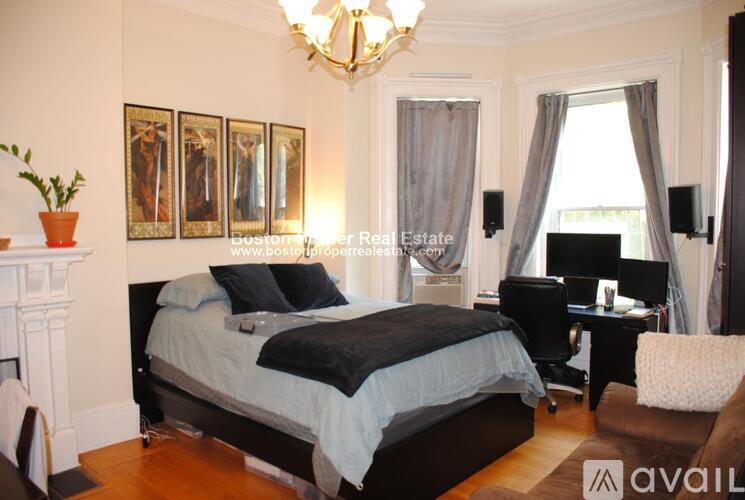 A bedroom with a large bed and a desk with a chair.