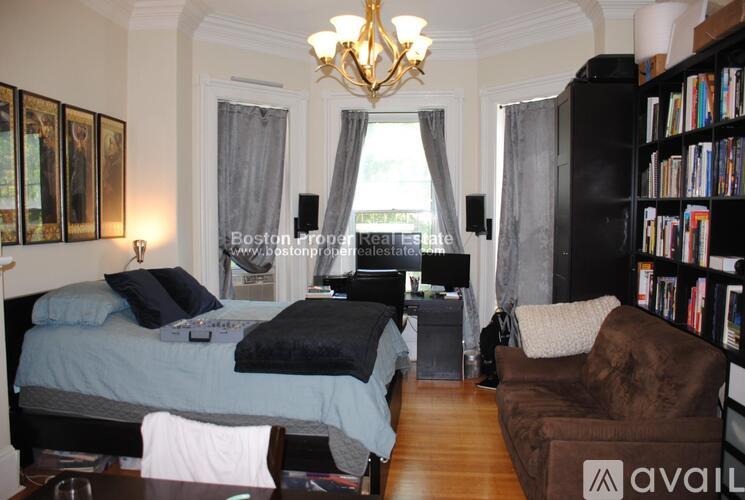 A bedroom with a bed, a chair, and a bookshelf.