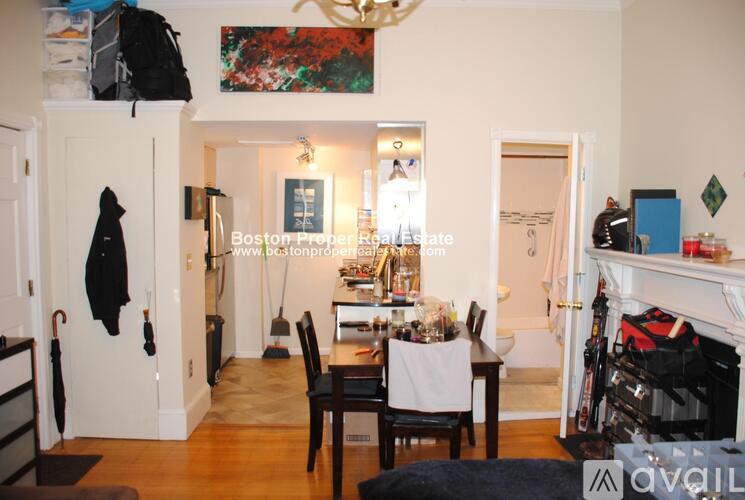 A dining room with a table set for two and a fireplace.