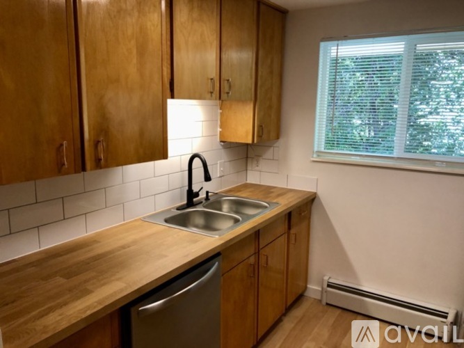 A kitchen with wooden cabinets and a stainless steel sink.