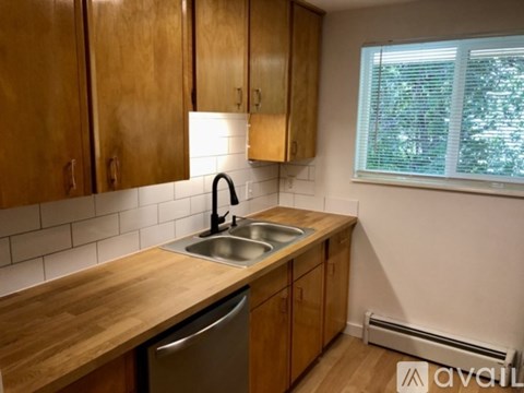 A kitchen with wooden cabinets and a stainless steel sink.