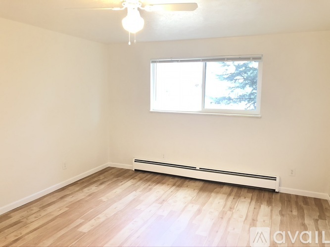 A room with a window and a ceiling fan.