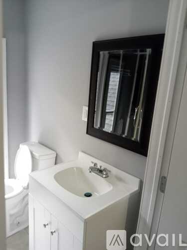 A bathroom with a white sink and a mirror above it.