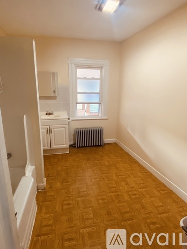 A room with wooden flooring and a window.