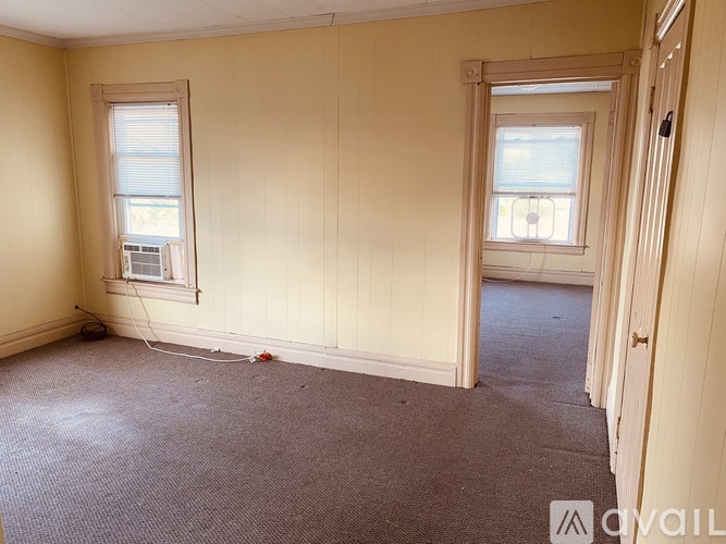 A room with two windows and a carpeted floor.