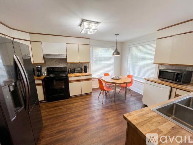 A kitchen with wooden floors and a table set for two.