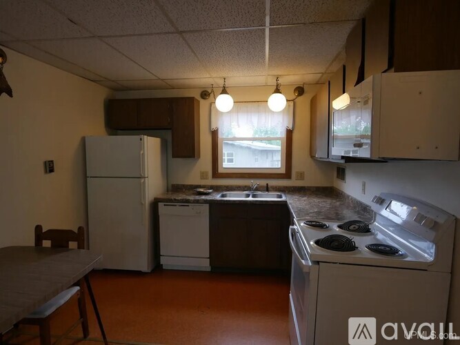 A kitchen with a white refrigerator, a white dishwasher, and a white stove top oven.