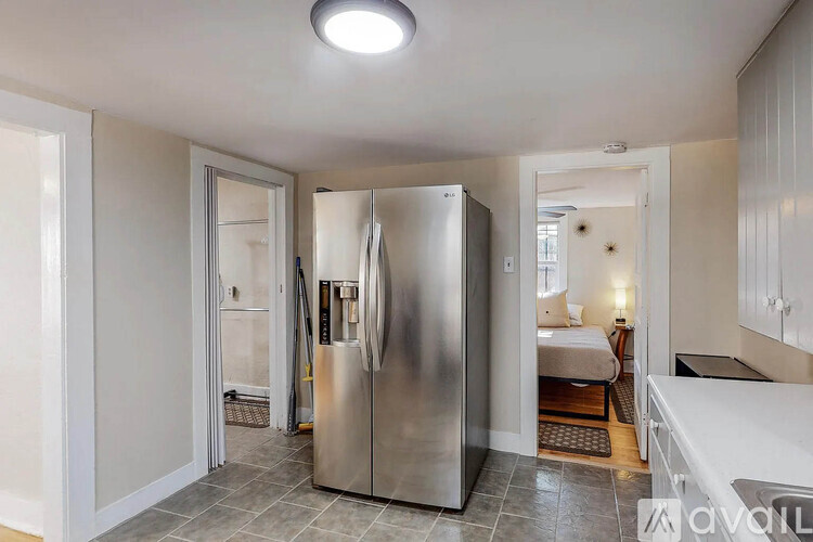 A stainless steel refrigerator is in the middle of a kitchen.