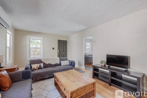 A living room with a grey couch and a wooden coffee table.