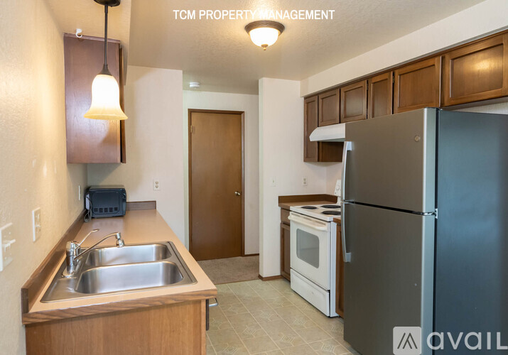 A kitchen with a sink, refrigerator, and microwave.