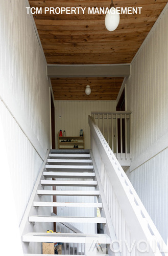 A staircase in a building under construction with the text "TCM PROPERTY MANAGEMENT" on the top.