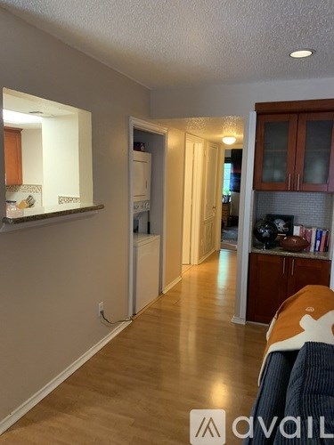 A living room with a couch and a kitchen area in the background.