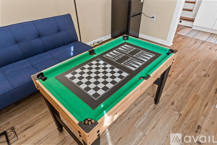 A pool table with a green felt top and a black and white checkerboard pattern on it.