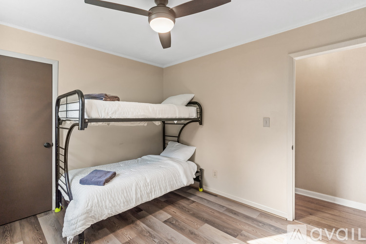 A bedroom with a bunk bed and a ceiling fan.
