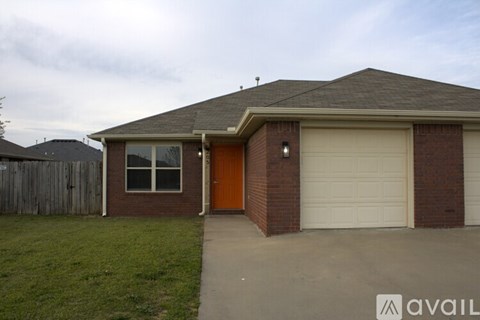 A house with a brown garage door and a brown fence.